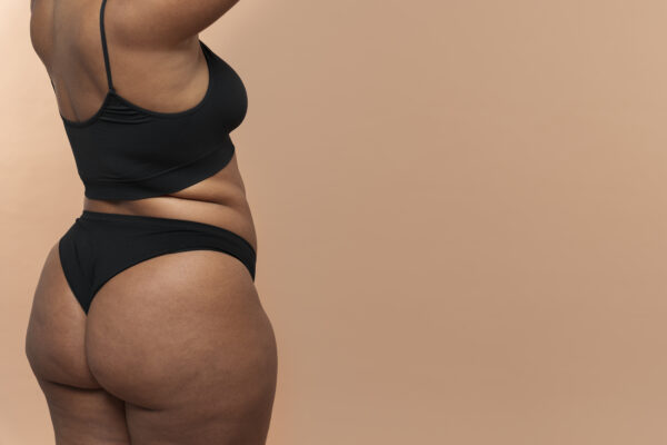 Curvy woman in black lingerie pose.